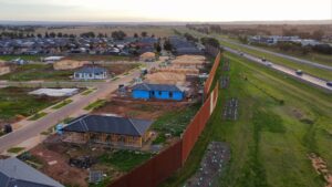 Aerial view of a freeway with an Australian compliant noise wall built by Wallmark Heuron Group to meet VicRoads design life regulations for noise walls.